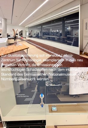 ein großzügiger Raum mit LIchtleisten an der Decke und Glasvitrinen ist zu sehen